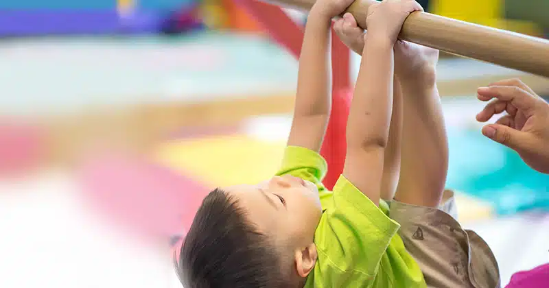 KID HANGING FROM BARRE